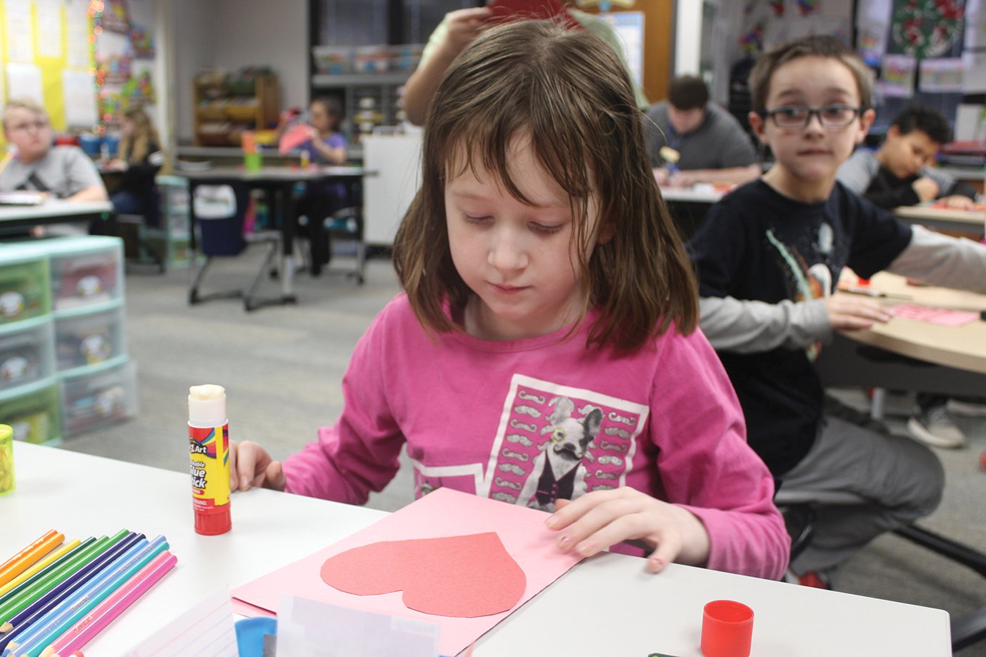 Viola Arnold inspects her work while she and her classmates create Valentine